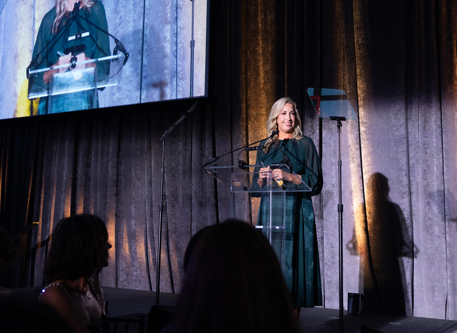 michelle wears black dress and speaks at a podium