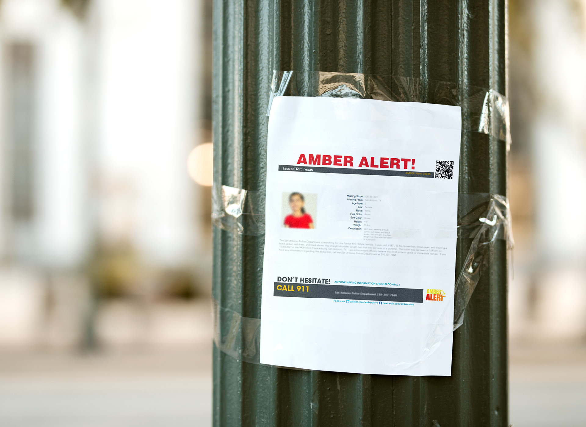 Missing child poster taped to street light post